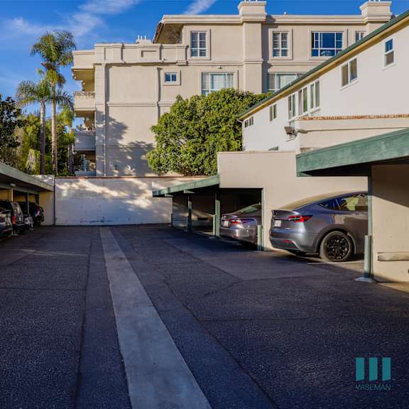 a street view of a residential area with cars parked on both sides.