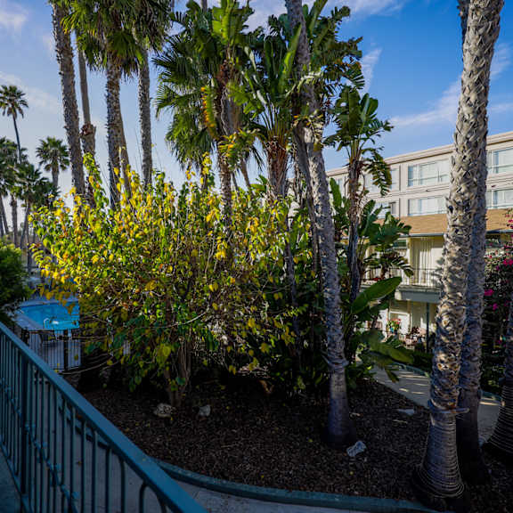 a balcony with a railing and a view of a building and trees.