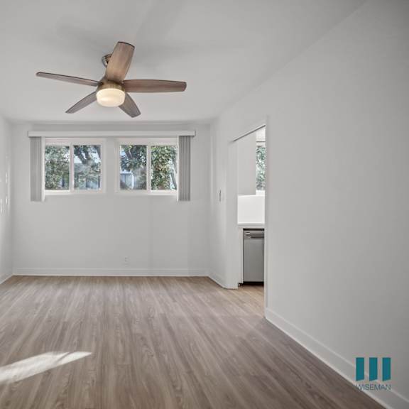 a room with a ceiling fan and a window with blinds.