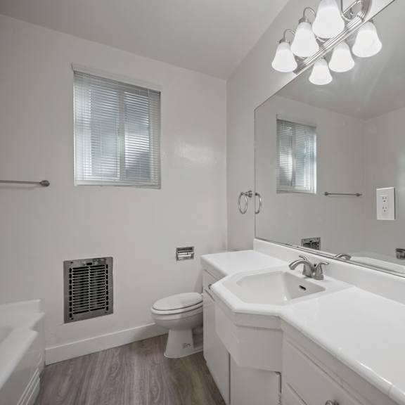 a white bathroom with a toilet, sink, and bathtub.