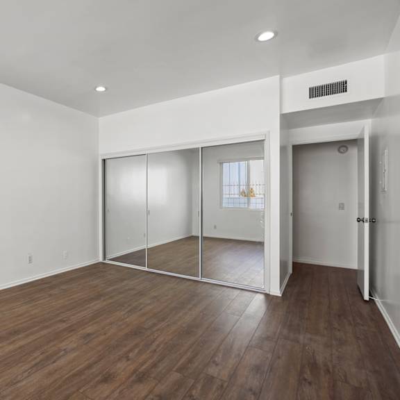 bedroom with large-size mirrored closet and vinyl flooring