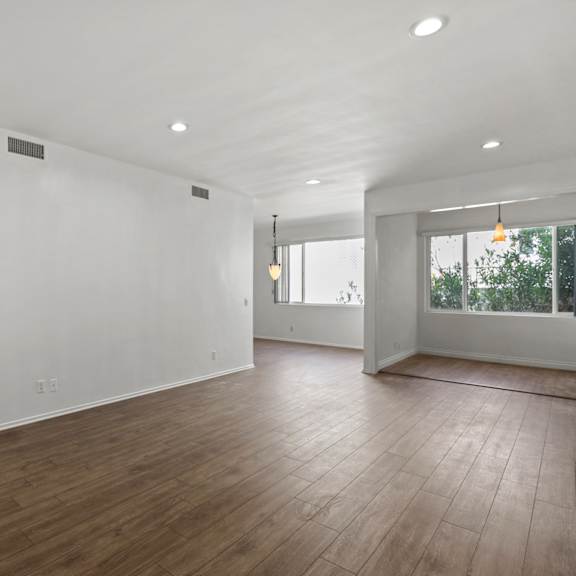an empty living room with white walls and hardwood floors