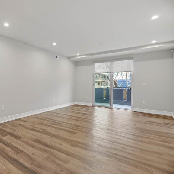 living room with recessed lighting, vinyl flooring, and patio with roll-down shades