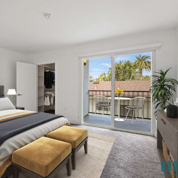 bedroom with walk-in closet with built-in organizers and spacious patio