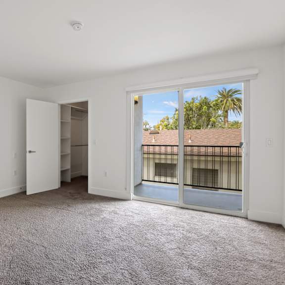 bedroom with walk-in closet and patio