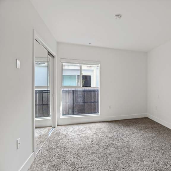 bedroom with mirrored closet and large-size windows