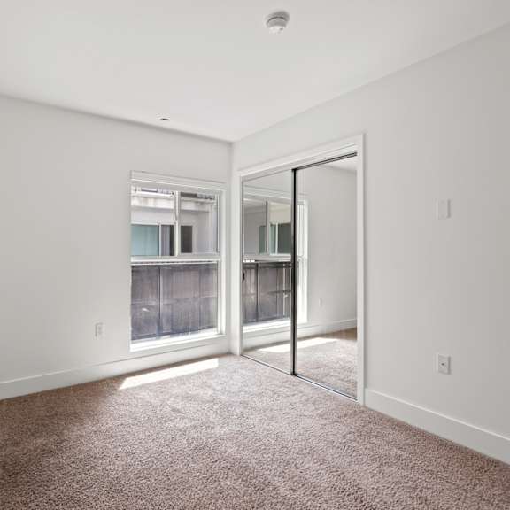 bedroom with mirrored closet and window