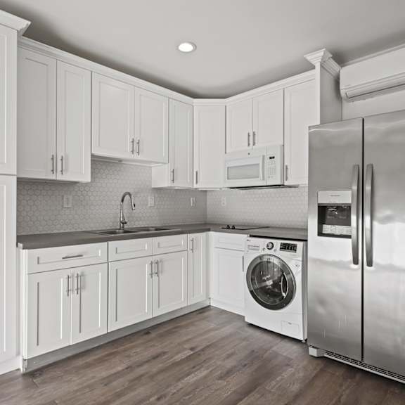 a modern kitchen with white cabinets and stainless steel appliances.