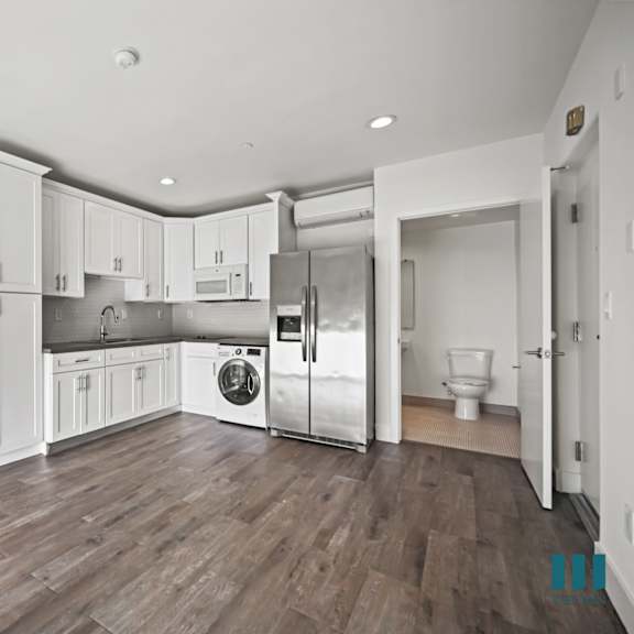 a kitchen with white cabinets and stainless steel appliances.