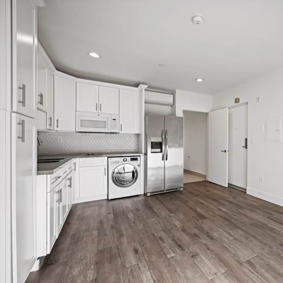 a kitchen with white cabinets and stainless steel appliances.