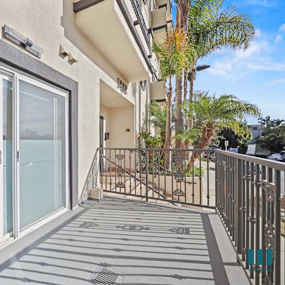 a balcony with a glass door leading to a kitchen.