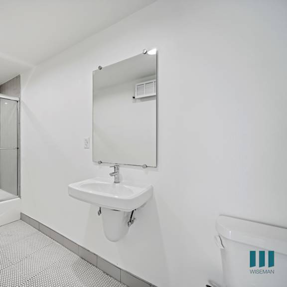 a bathroom with a white sink and a glass shower stall.