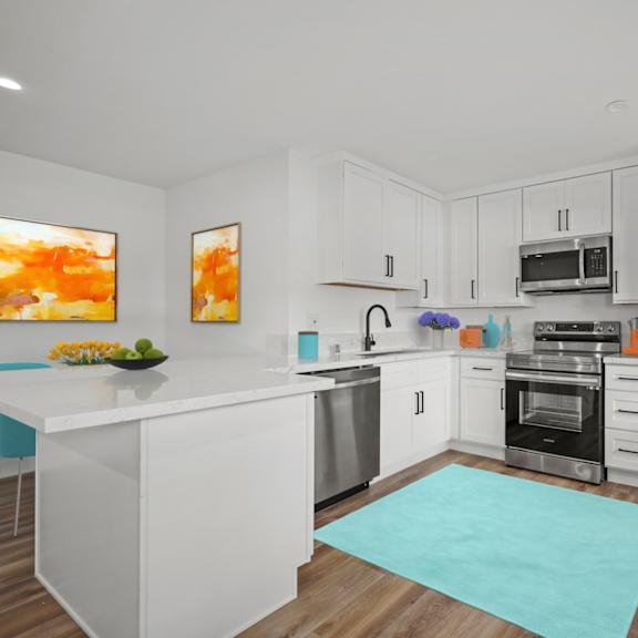 a modern kitchen with white cabinets and stainless steel appliances.