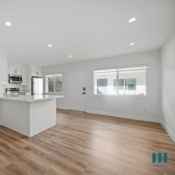 a kitchen with wooden floors and white walls.