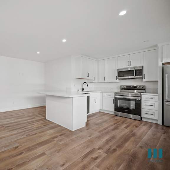a modern kitchen with white cabinets and stainless steel appliances.