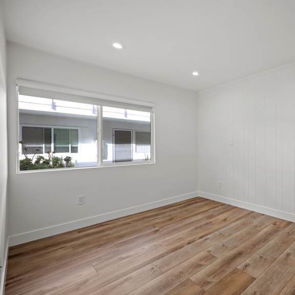 a room with wooden flooring and a window.