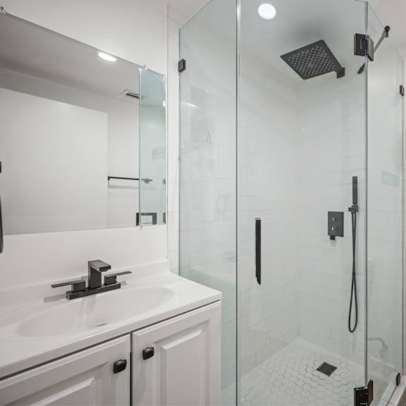 a white bathroom with a walk in shower.