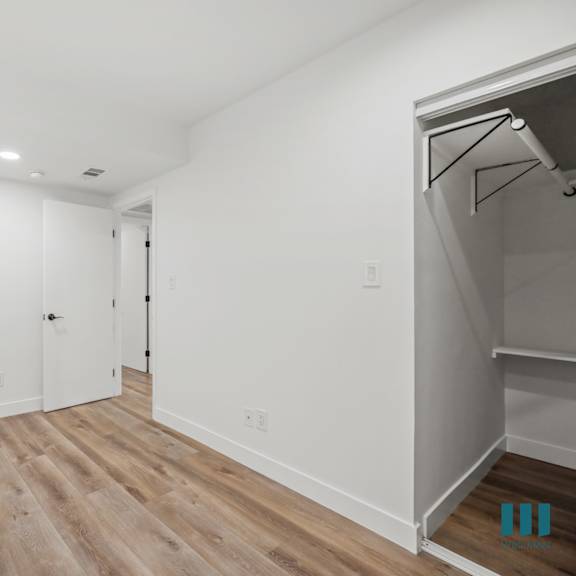 a room with wooden flooring and white walls.