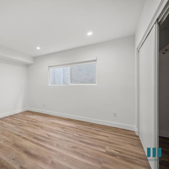 a room with wooden flooring and a window.