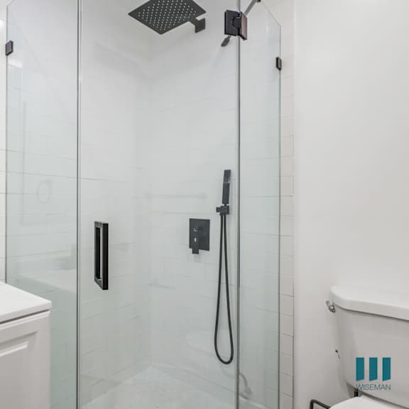 a white bathroom with a glass shower stall and a white tub.