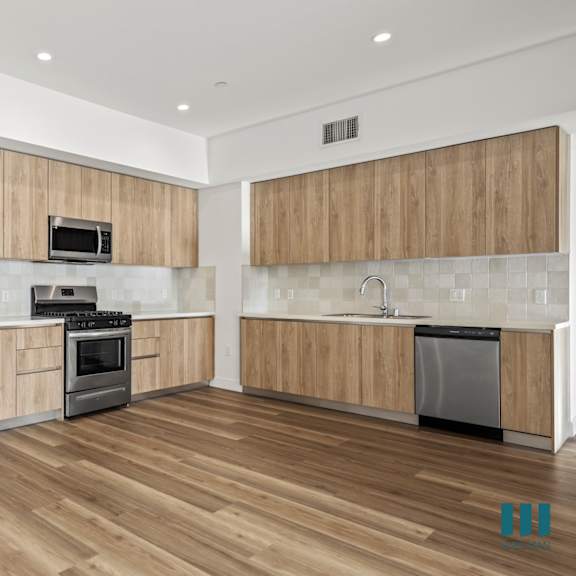 a modern kitchen with wooden cabinets and stainless steel appliances.