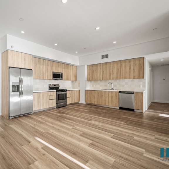 a kitchen with wooden floors and stainless steel appliances.