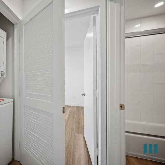 a white fridge in a kitchen with a white door.