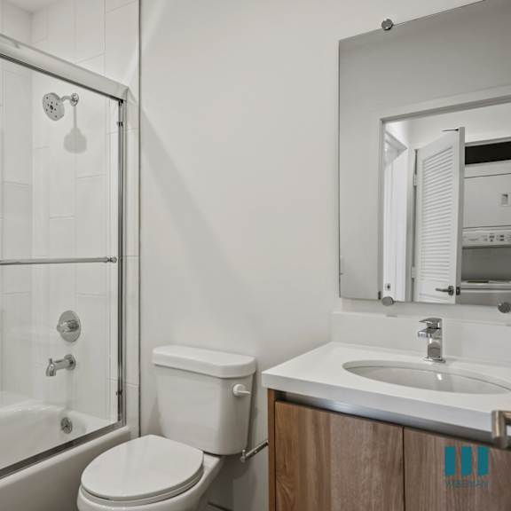 a white toilet sits next to a sink in a bathroom.