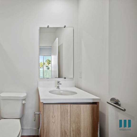 a bathroom with a white toilet, sink, and a glass shower stall.