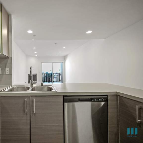 a modern kitchen with a stainless steel dishwasher and a black stove top.
