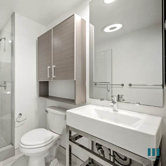 a white toilet sits next to a sink in a modern bathroom.