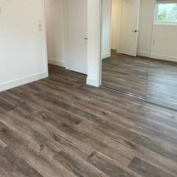 bedroom with mirrored closet and vinyl flooring