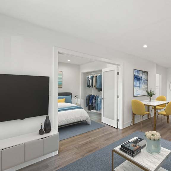 a living room with a tv and a bedroom in the background
