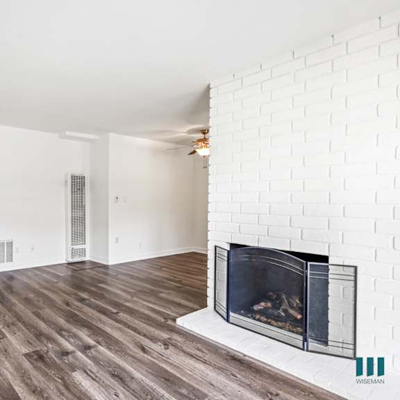 open-concept living room with a fireplace and vinyl flooring