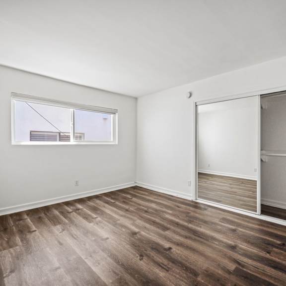 bedroom with large-size mirrored closet and vinyl flooring
