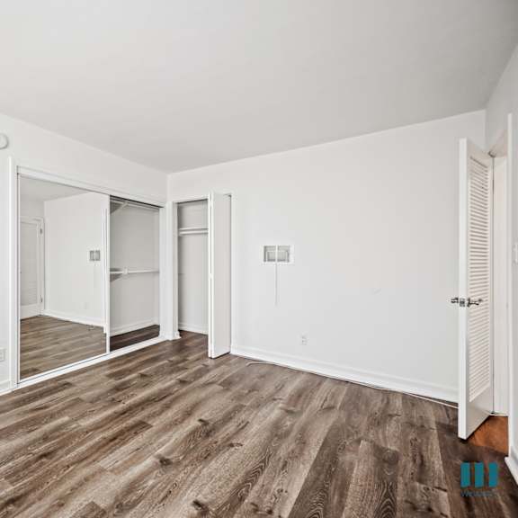 bedroom with vinly flooring and mirrored closet