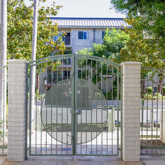 a gate with a house behind it behind a fence