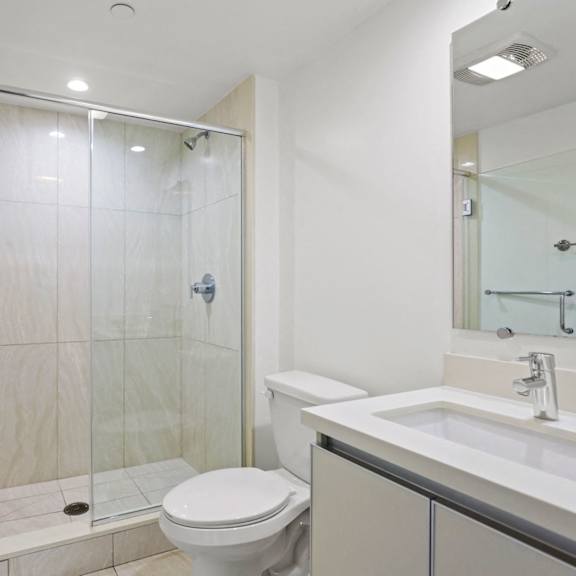 bathroom with walk-in shower and vanity cabinet storage