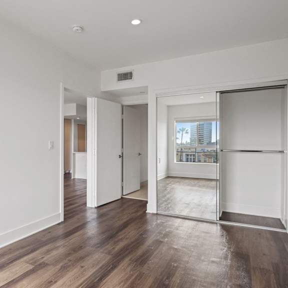 bedroom with mirrored closet, vinyl flooring, and recessed lighting