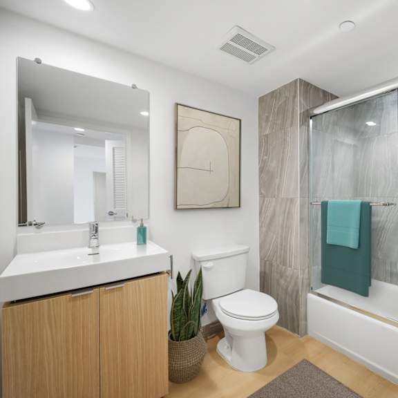 a bathroom with a white toilet, a white sink, and a glass shower stall.