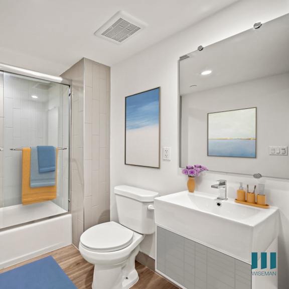 a bathroom with a white toilet, sink, and bathtub.