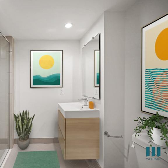 a bathroom with a shower, sink, and two framed pictures on the wall.
