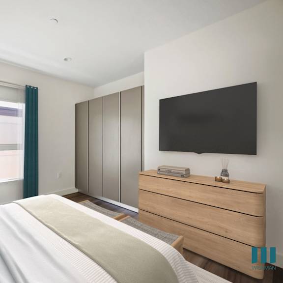 a bedroom with a bed and a tv on the wall