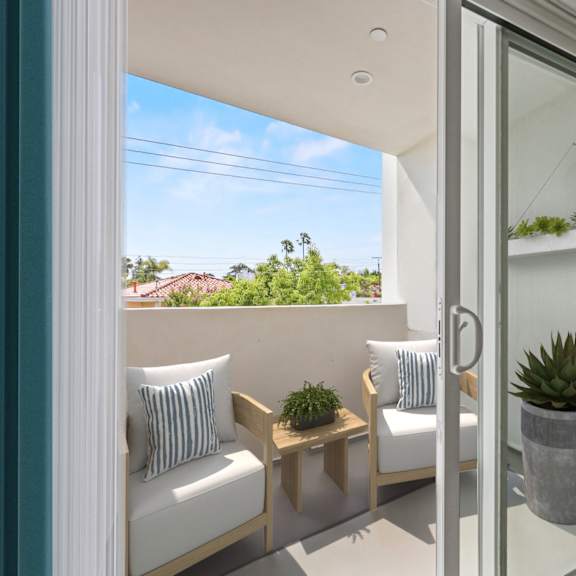 a patio with two chairs and a table and a sliding glass door
