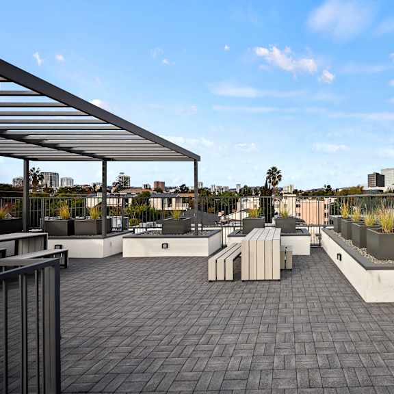 a rooftop patio with a metal railing and a metal awning.