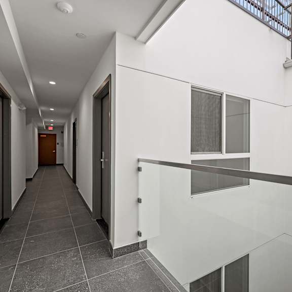 a long hallway with a skylight and a white wall on the side.