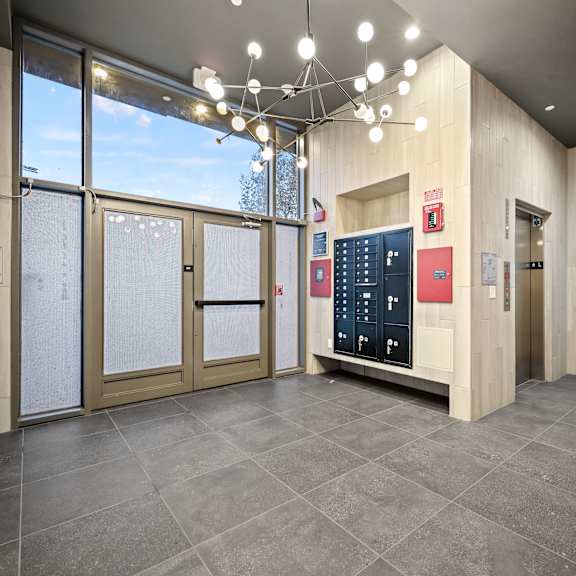 a modern office lobby with a reception desk and a large window.