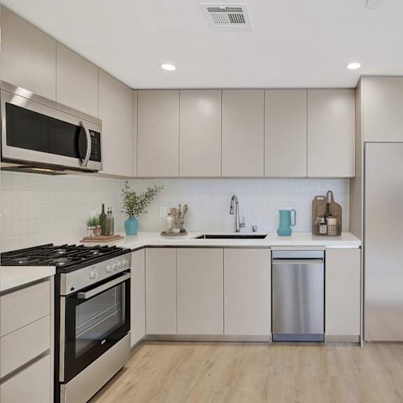 a kitchen with a stainless steel dishwasher and a fridge.