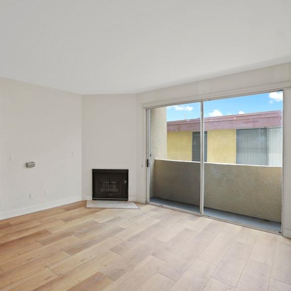dining and living room space with vinyl flooring, fireplace, and balcony