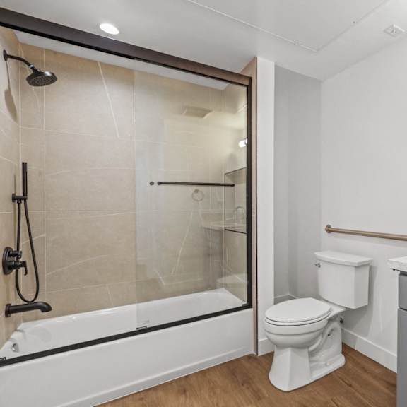 bathroom with shower-bath with glass door and vanity cabinet storage